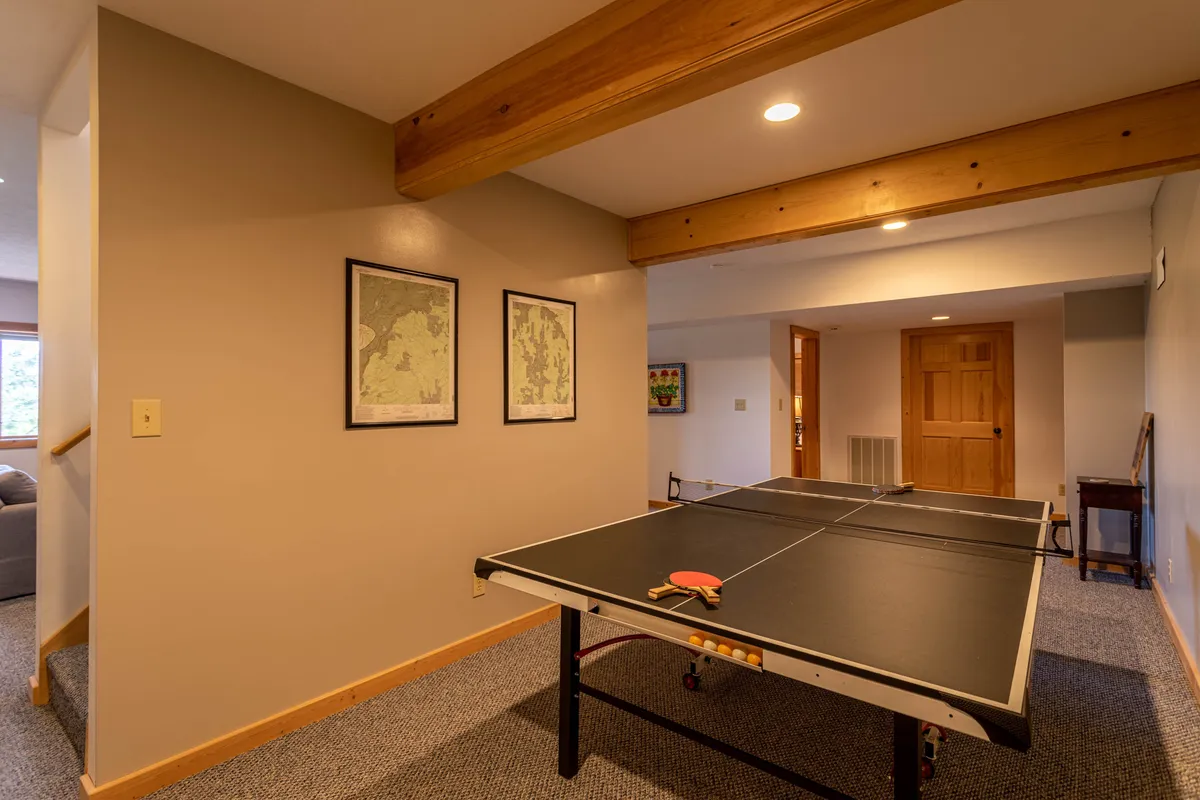 A lively game room interior with a ping pong table, wooden beams, and cheerful decor. The space is designed for friendly competition and group gatherings, reinforcing fun and play as central themes of the retreat.